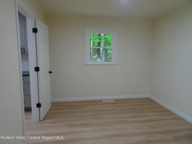 an empty room with wooden floor and window
