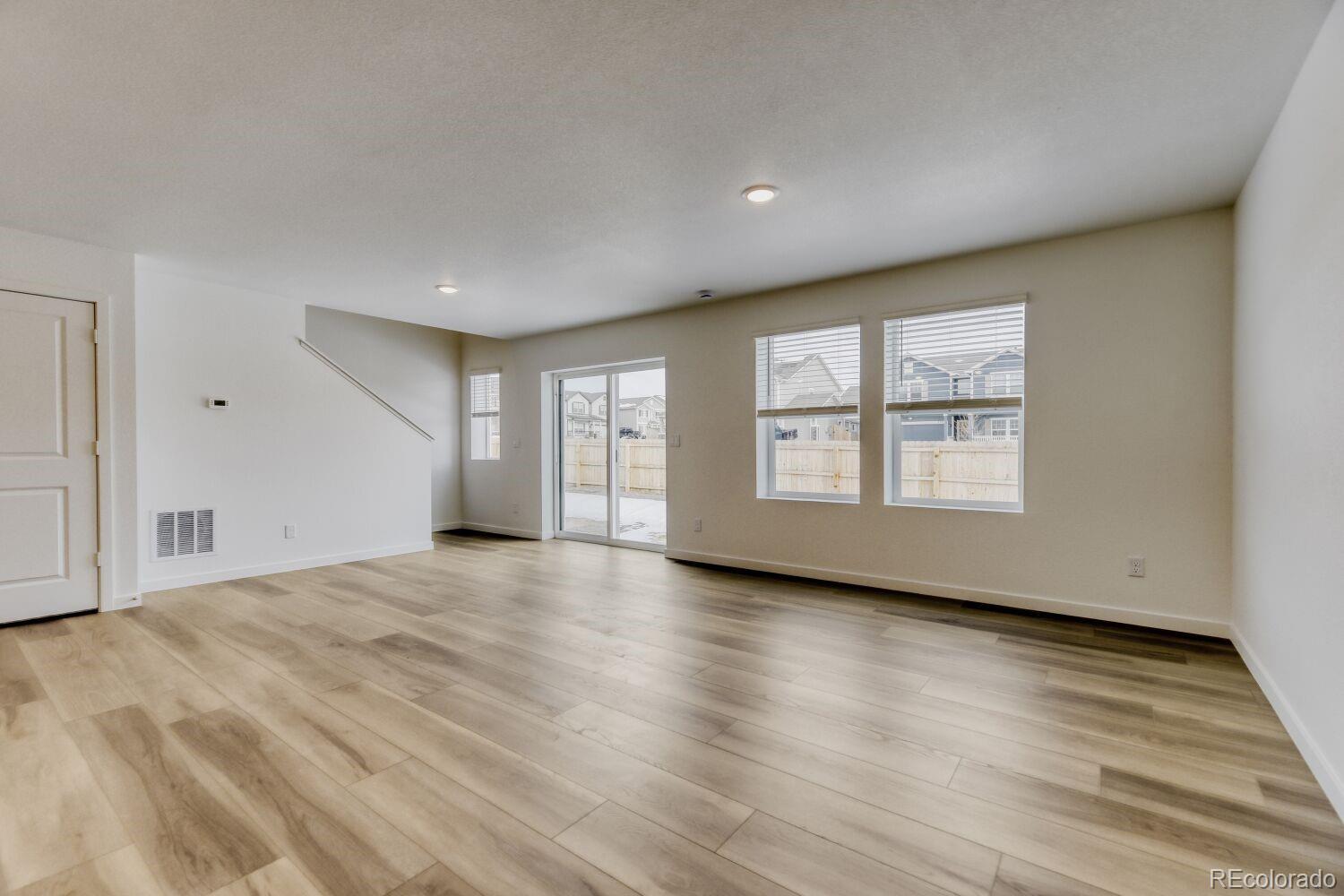 8962 Blue Feather Loop Colorado Springs, CO 80908 - Photo 2 of 18 an empty room with wooden floor and windows