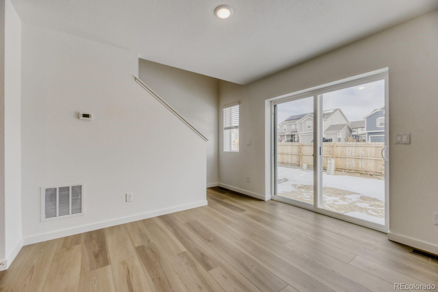 8962 Blue Feather Loop Colorado Springs, CO 80908 - Photo 3 of 18 a view of an empty room with wooden floor and a window