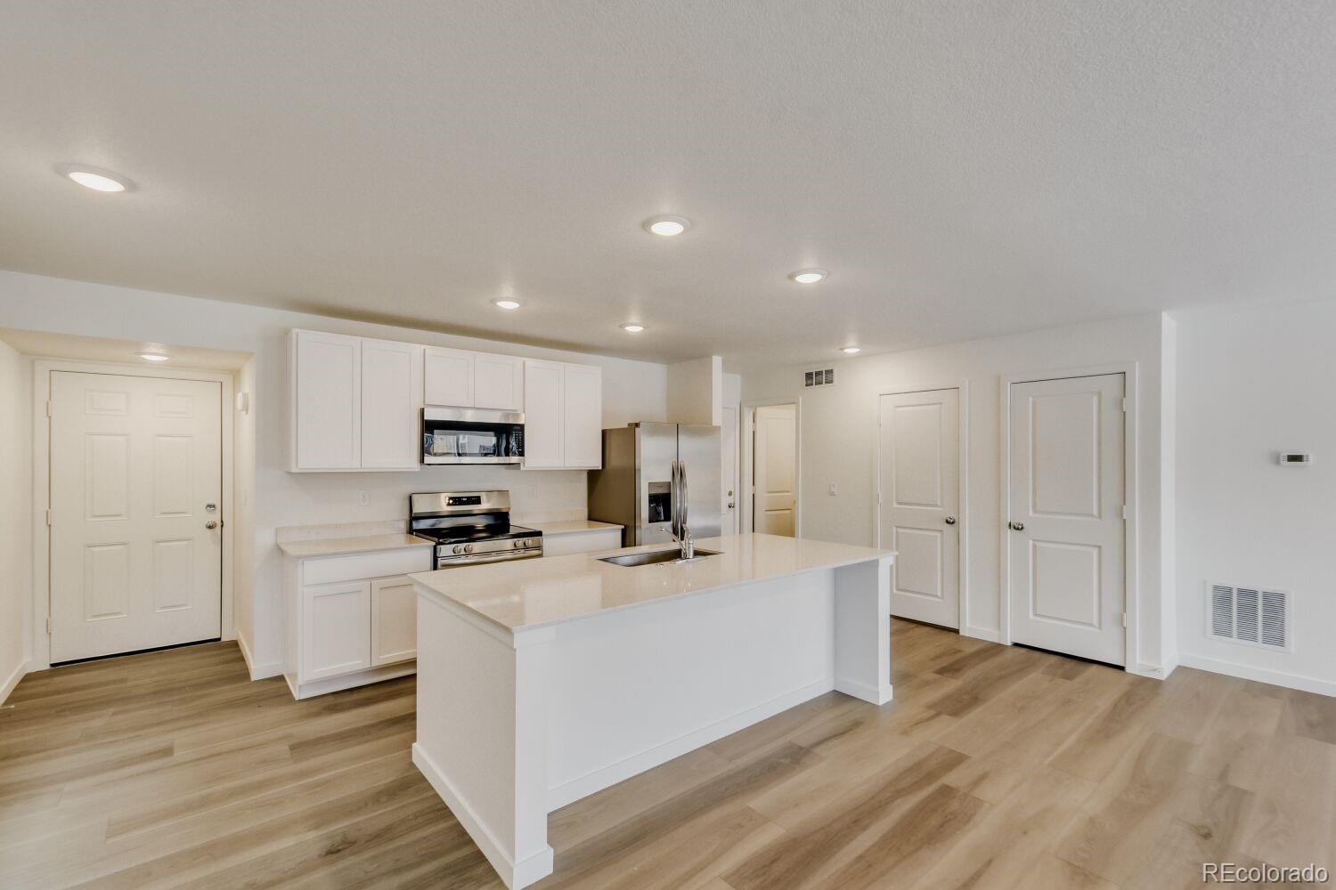 8962 Blue Feather Loop Colorado Springs, CO 80908 - Photo 5 of 18 a kitchen with stainless steel appliances a refrigerator sink and cabinets