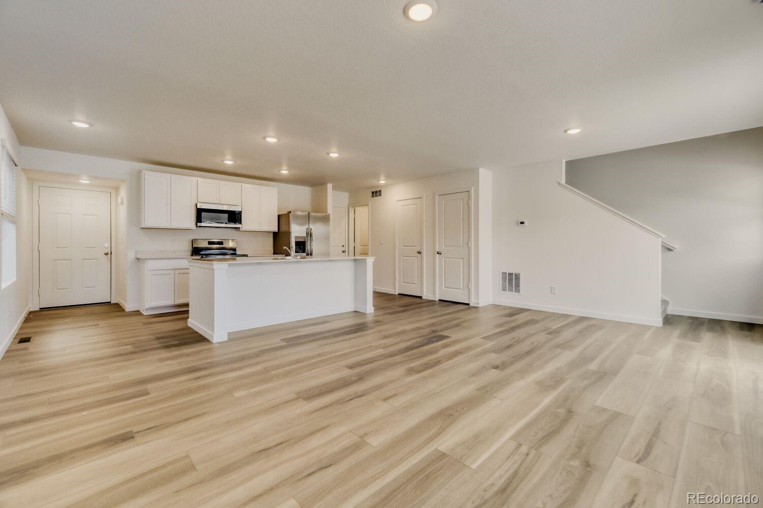 8962 Blue Feather Loop Colorado Springs, CO 80908 - Photo 6 of 18 a view of kitchen with refrigerator stove microwave and cabinets