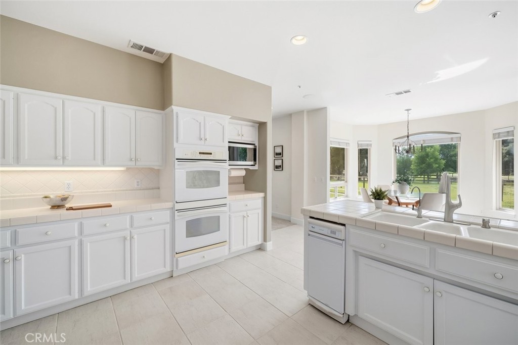 1825 Hi Mountain Road Arroyo Grande, CA 93420 - Photo 18 of 74 a kitchen with granite countertop white cabinets and white appliances