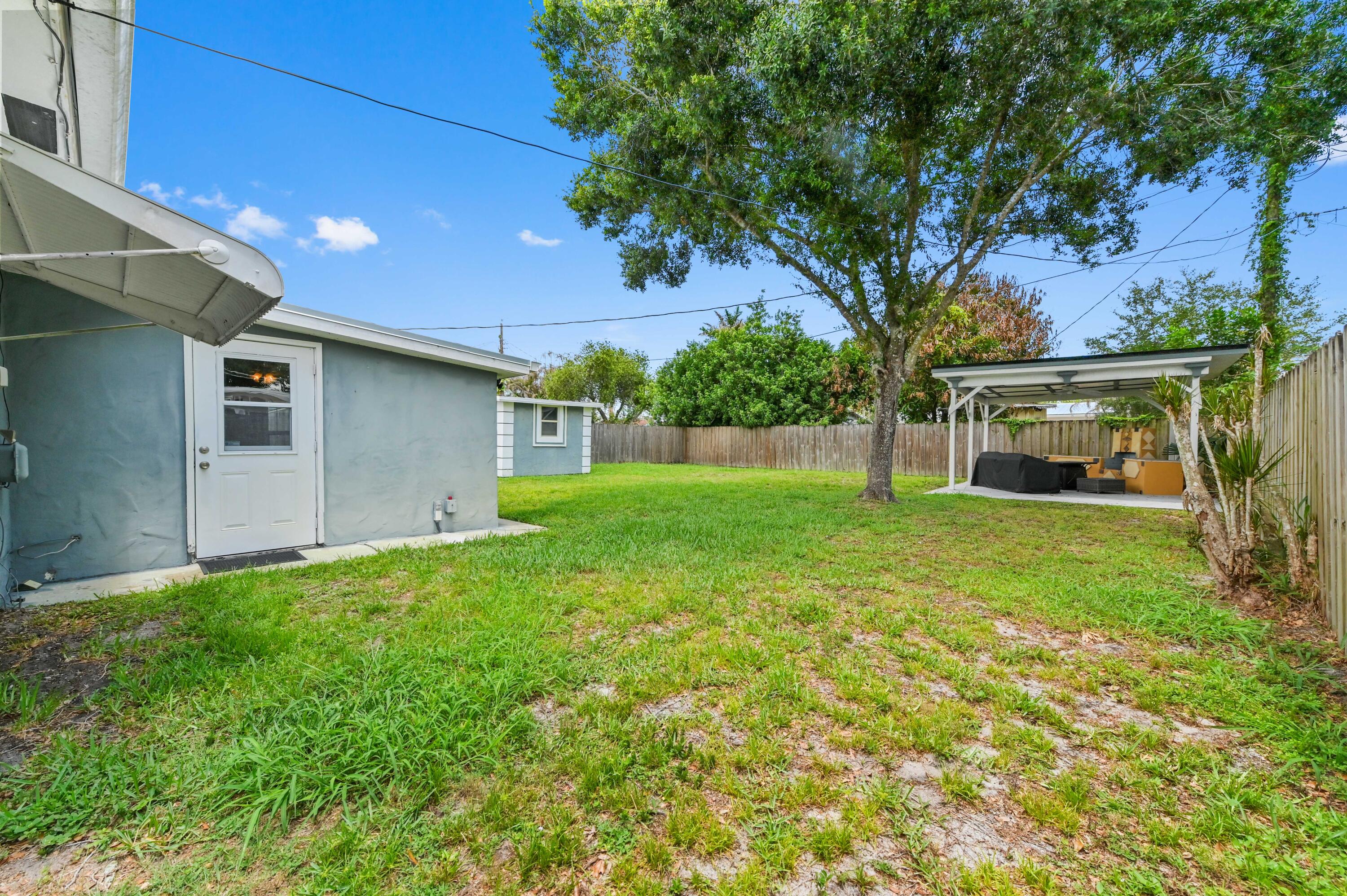 5709 Southeast Indigo Avenue Stuart, FL 34997 - Photo 23 of 26 a view of a backyard with a garden
