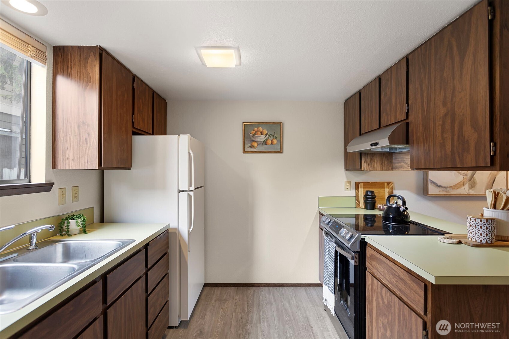 9545 Interlake Avenue North Seattle, WA 98103 - Photo 13 of 32 a kitchen with stainless steel appliances granite countertop a refrigerator sink and wooden cabinets