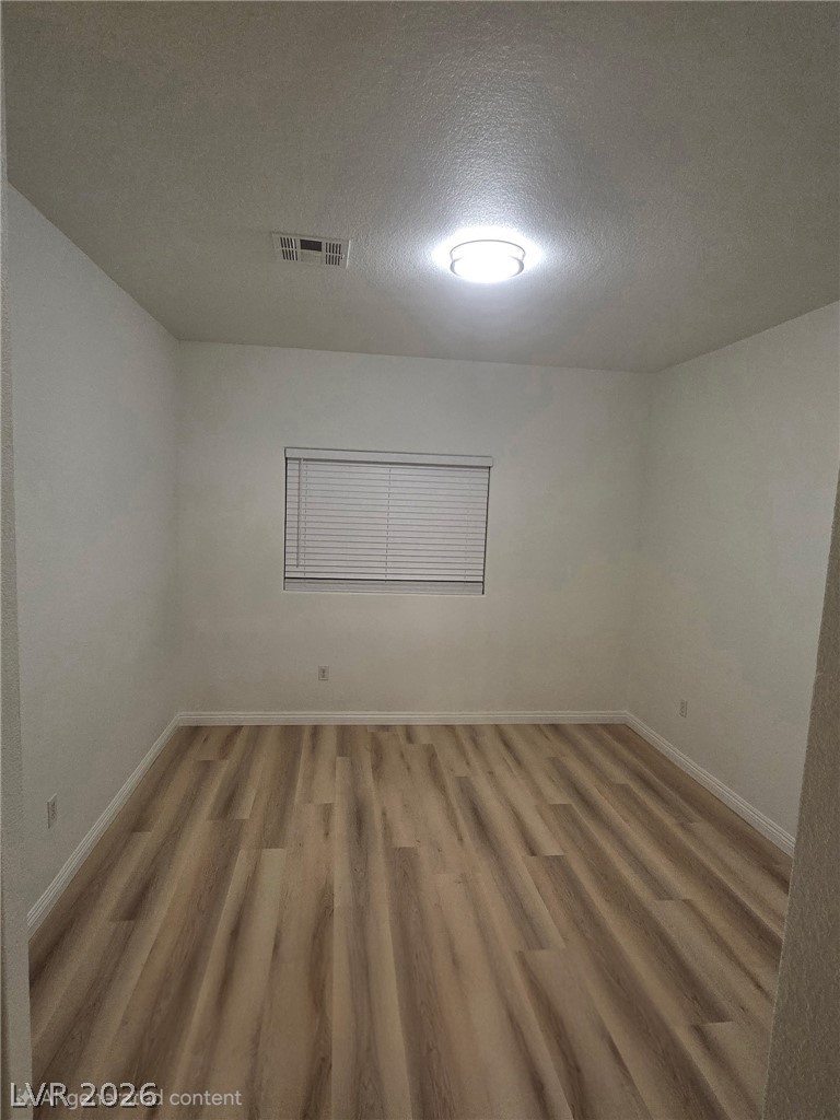 4730 East Craig Road, Unit 1062 Las Vegas, NV 89115 - Photo 4 of 8 A versatile room awaits your personal touch, featuring durable plank flooring and a bright overhead light.