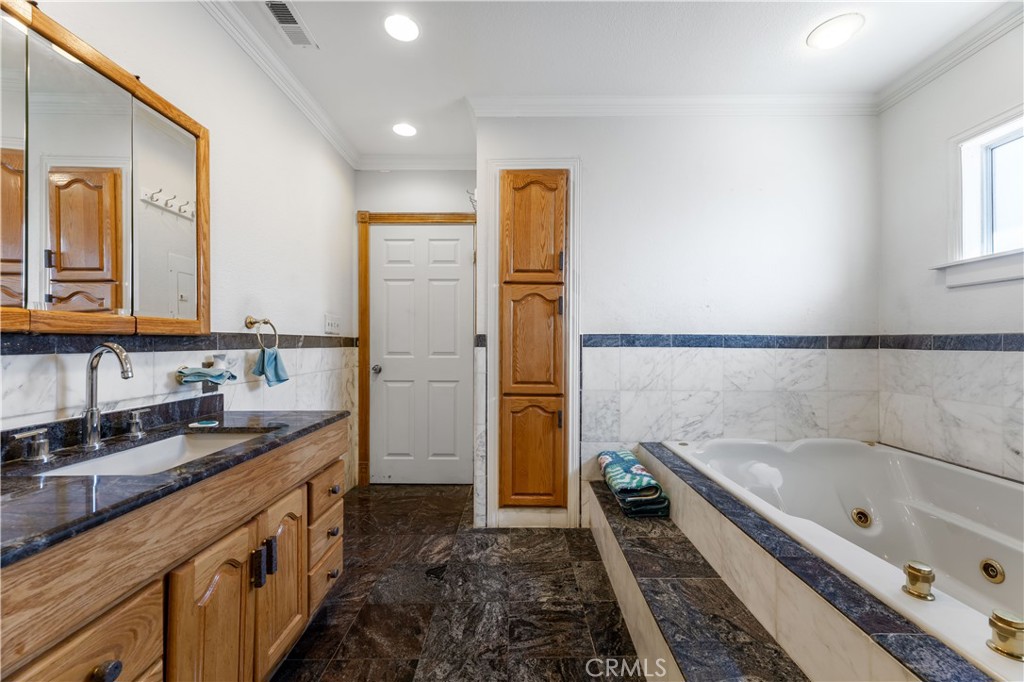 11203 Sheldon Street Sun Valley, CA 91352 - Photo 16 of 57 a bathroom with a granite countertop double vanity sink a mirror and a bathtub