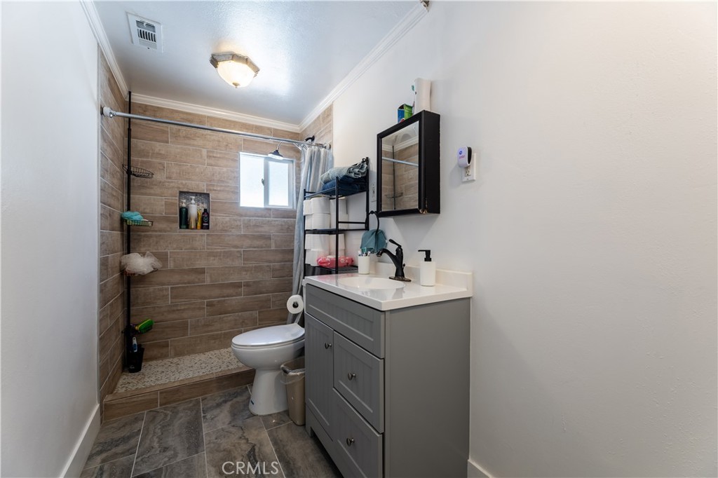 11203 Sheldon Street Sun Valley, CA 91352 - Photo 23 of 57 a bathroom with a toilet sink and mirror