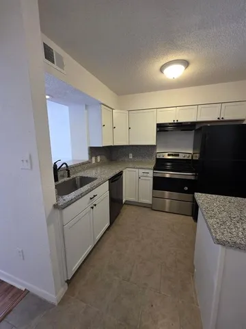 a kitchen with a sink and a stove top oven