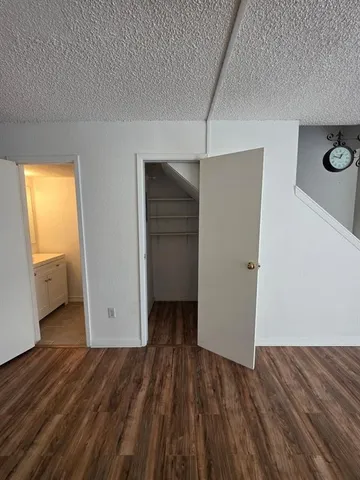 an empty room with closet and wooden floor