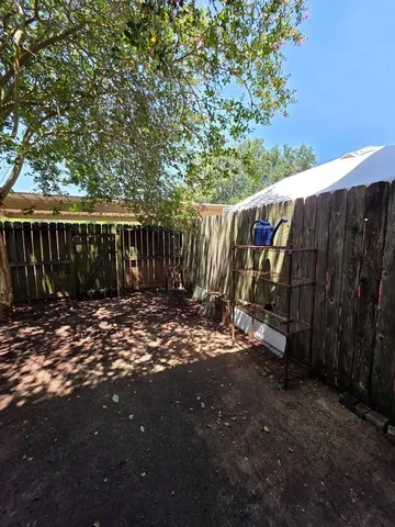 a view of a backyard with wooden fence
