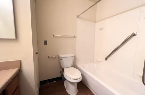 a white toilet sitting next to a bathroom sink and vanity