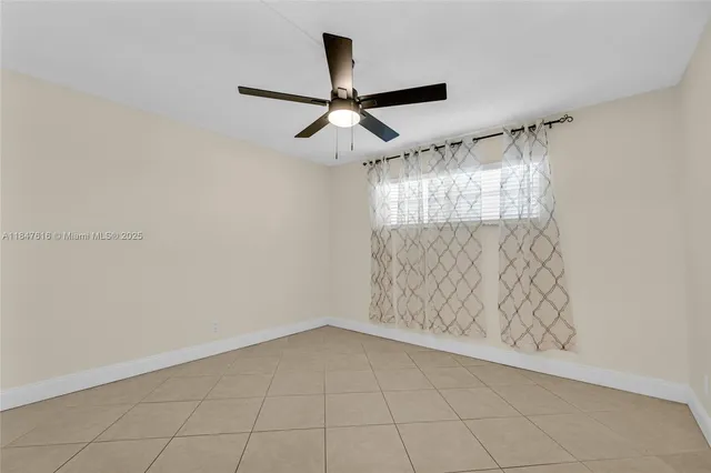 en empty room with window and ceiling fan