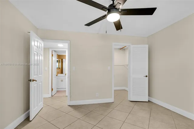 an empty room with closet and a chandelier fan