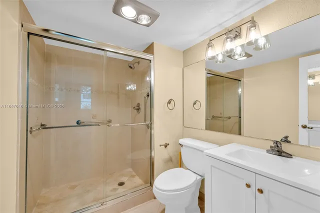 a bathroom with a sink mirror toilet and shower