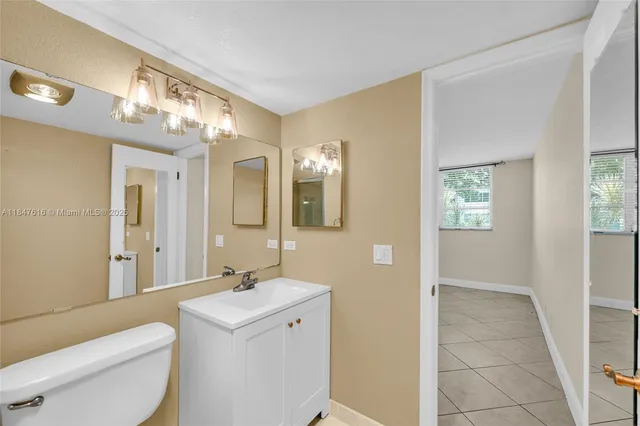 a spacious bathroom with a toilet sink and mirror