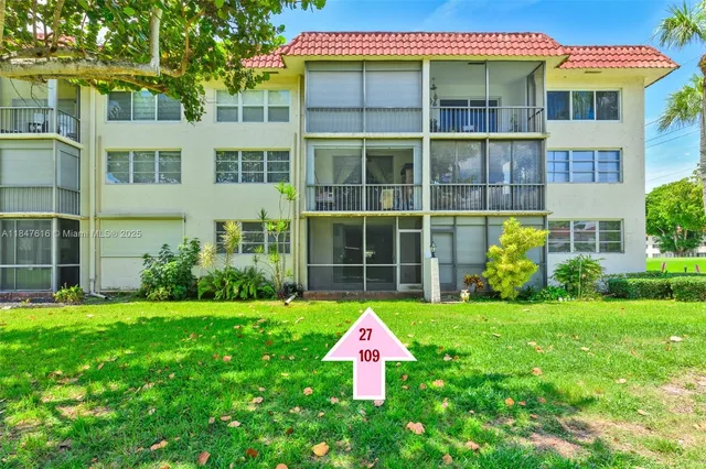 a front view of a multi story residential apartment building with a yard