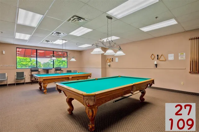 a room with pool table and windows