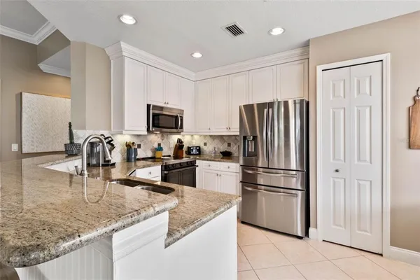 a kitchen with granite countertop a refrigerator a stove and a sink