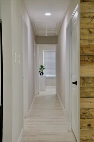 a view of a hallway with wooden shelves