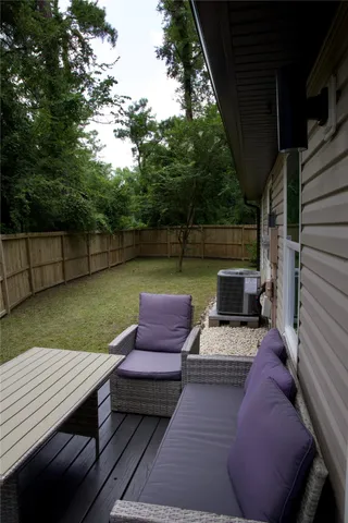 a view of a deck with couches table and chairs with wooden floor and fence