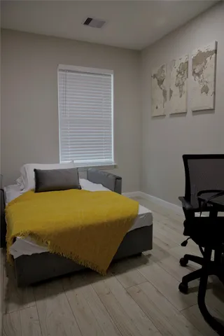 a bedroom with a bed and wooden floor