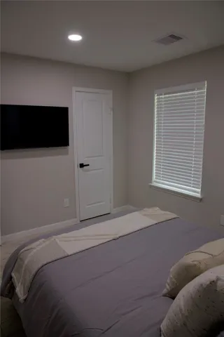 a bedroom with a bed and a television