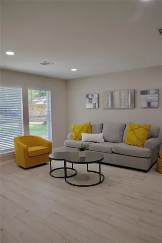 a living room with furniture a rug and a large window