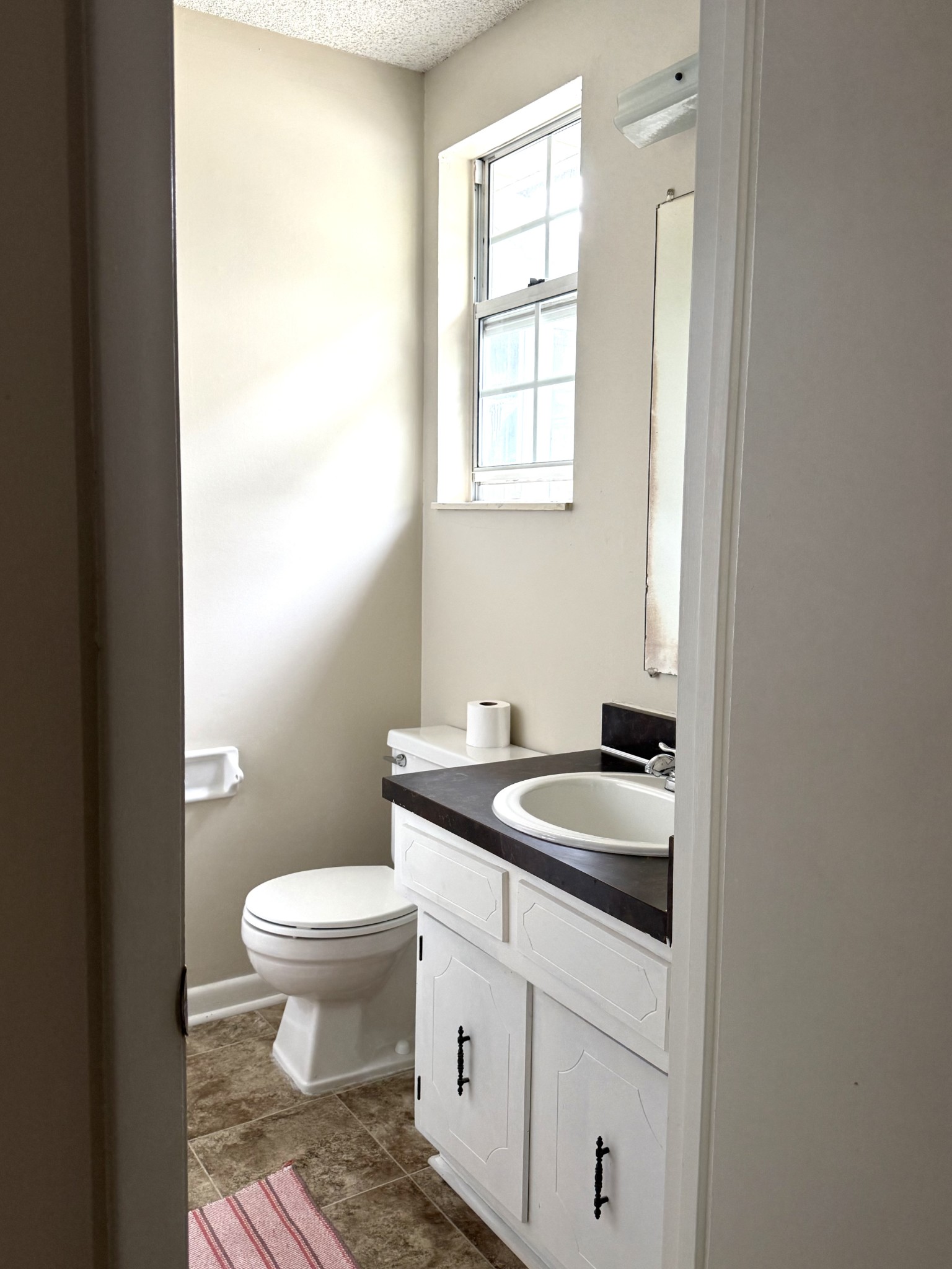 3308 Shakertown Road Antioch, TN 37013 - Photo 12 of 28 a bathroom with a granite countertop toilet a sink and a window