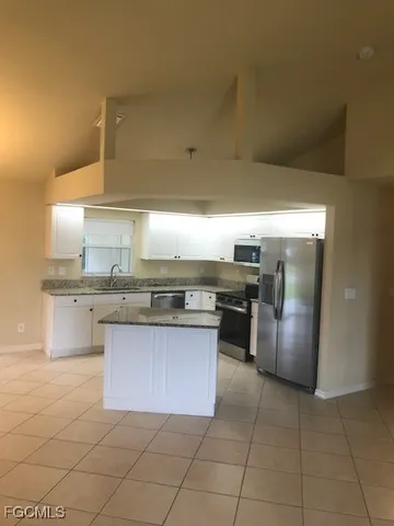 a kitchen with stainless steel appliances granite countertop a sink counter and a stove
