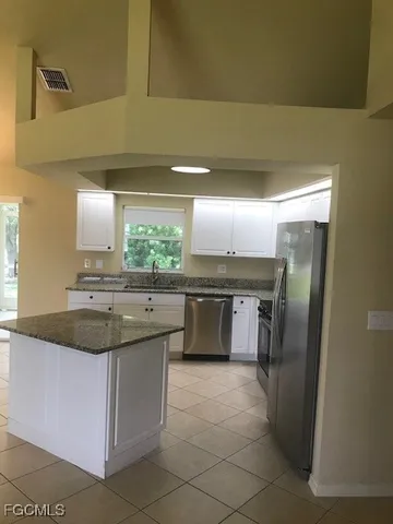 a kitchen with stainless steel appliances granite countertop a sink and a refrigerator