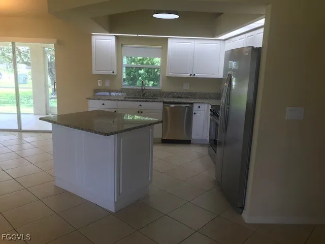 a kitchen with stainless steel appliances granite countertop a sink and a refrigerator