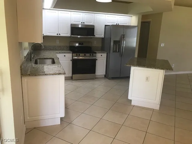 a kitchen with granite countertop a stove and a refrigerator