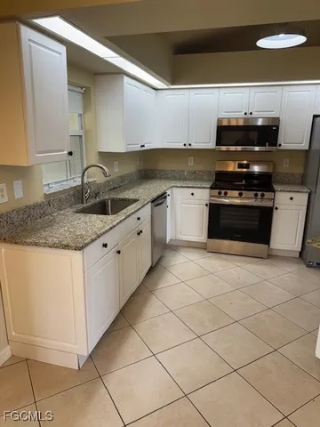 a kitchen with stainless steel appliances granite countertop a sink and a stove