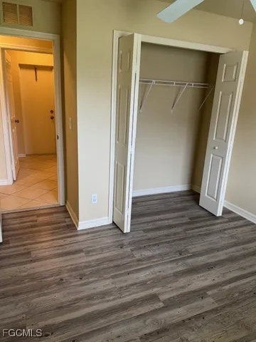 an empty room with wooden floor and entrance