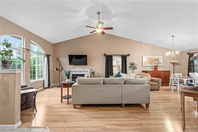 a living room with furniture a flat screen tv and a large window