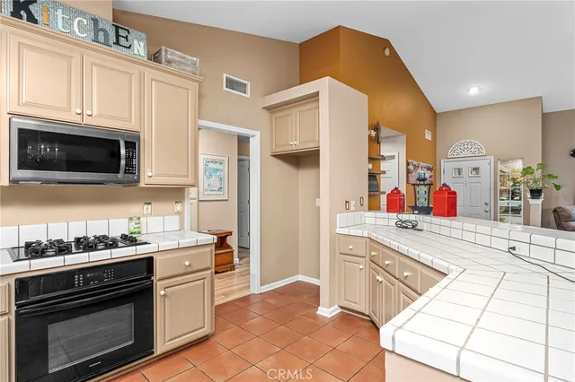 a kitchen with stainless steel appliances kitchen island granite countertop a stove a sink and a microwave