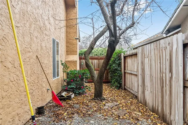 a view of a chair and table in backyard of the house