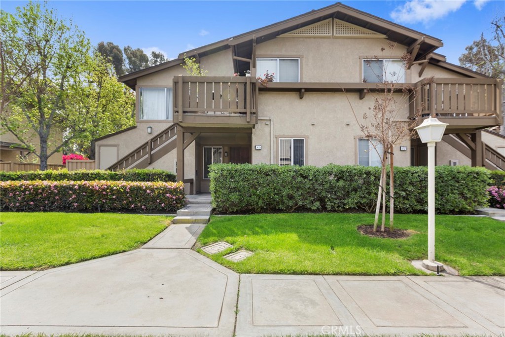 a view of a white house with a yard and potted plants
