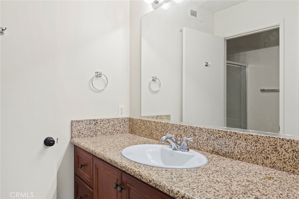 86 Clearbrook, Unit 33 Irvine, CA 92614 - Photo 17 of 20 a bathroom with a granite countertop sink a mirror and shower