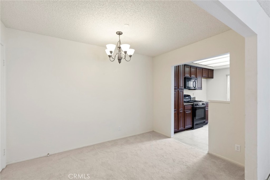 86 Clearbrook, Unit 33 Irvine, CA 92614 - Photo 8 of 20 an empty room with kitchen view and stainless steel appliances