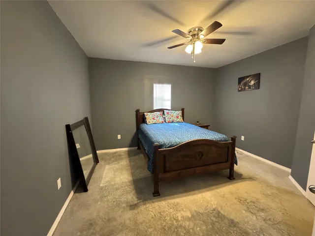 a bedroom with a bed and a ceiling fan