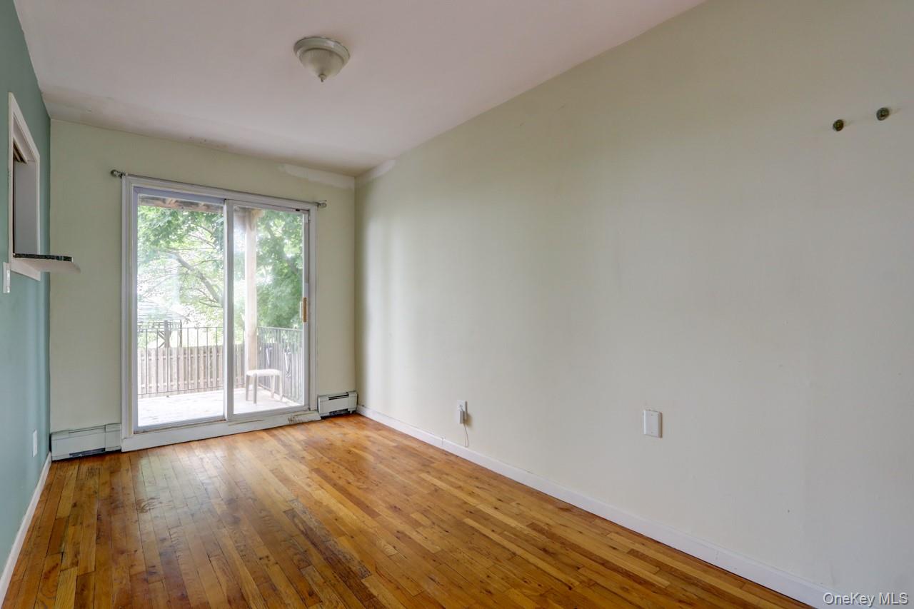 12-67 Waterview Street Queens, NY 11691 - Photo 12 of 14 a view of an empty room with wooden floor and a window