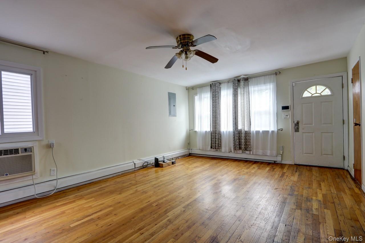 12-67 Waterview Street Queens, NY 11691 - Photo 4 of 14 a view of a room with wooden floor and windows