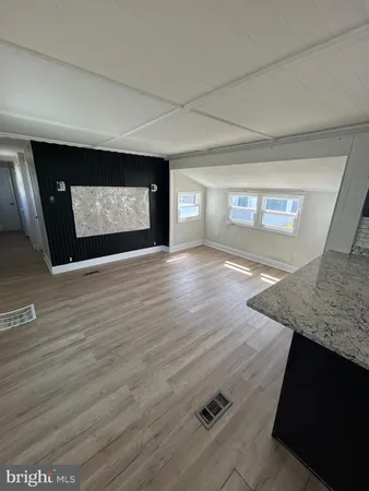 a view of a hallway with wooden floor and fireplace