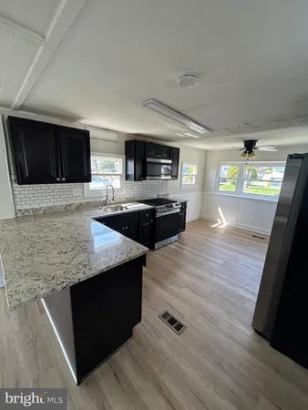 a kitchen with stainless steel appliances wooden cabinets a sink and a stove
