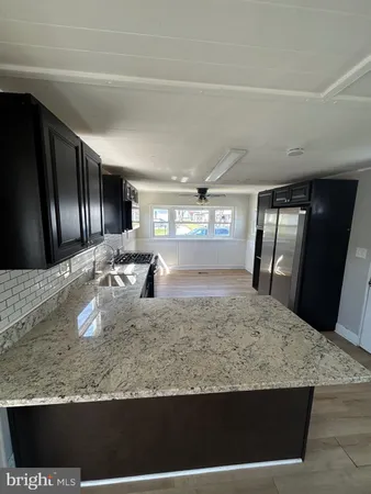 a view of a kitchen with granite countertop sink and natural light