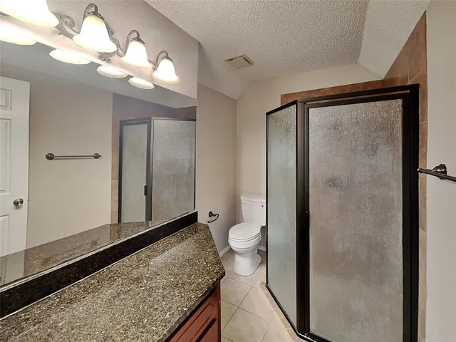 a bathroom with a granite countertop sink a toilet and a mirror