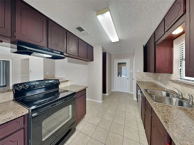 a kitchen with granite countertop a stove and a sink
