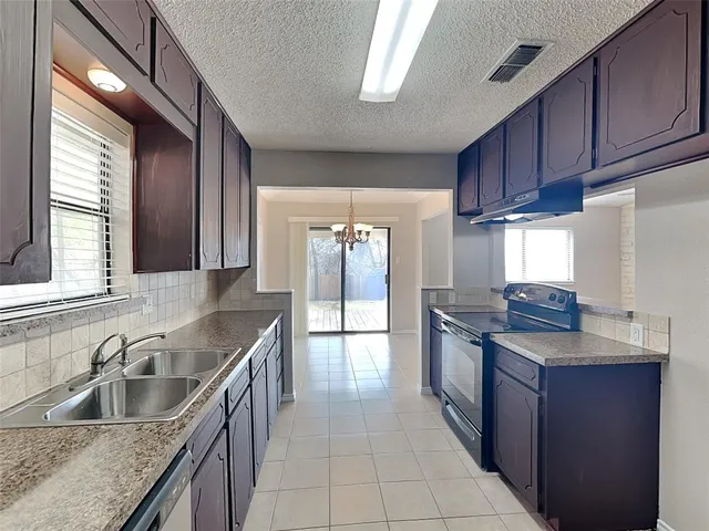a kitchen with stainless steel appliances granite countertop a sink stove and cabinets
