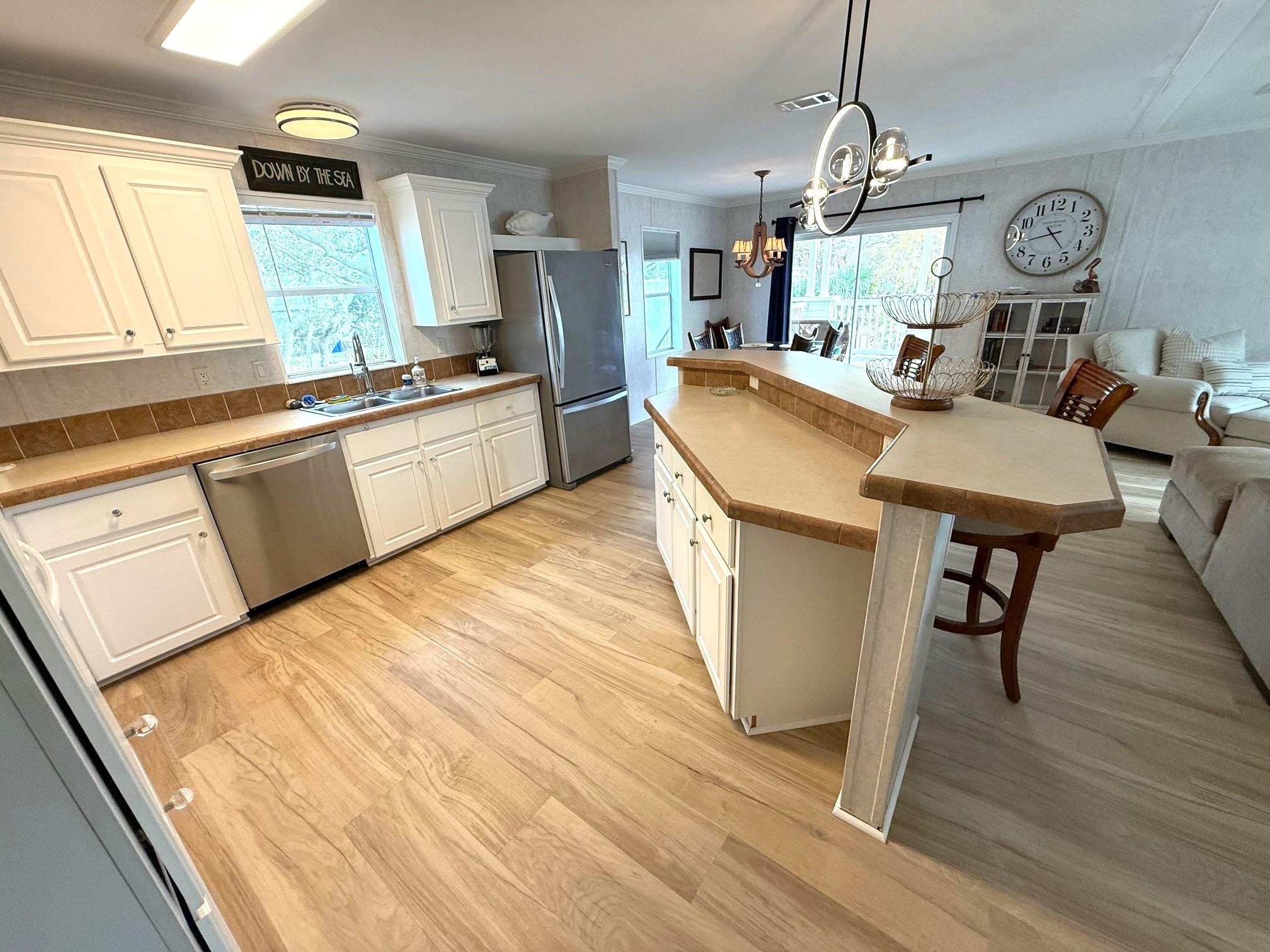 292 Majorca Road St. Augustine, FL 32080 - Photo 31 of 32 Kitchen with a kitchen breakfast bar, white cabinets, open floor plan, a kitchen island, and ornamental molding
